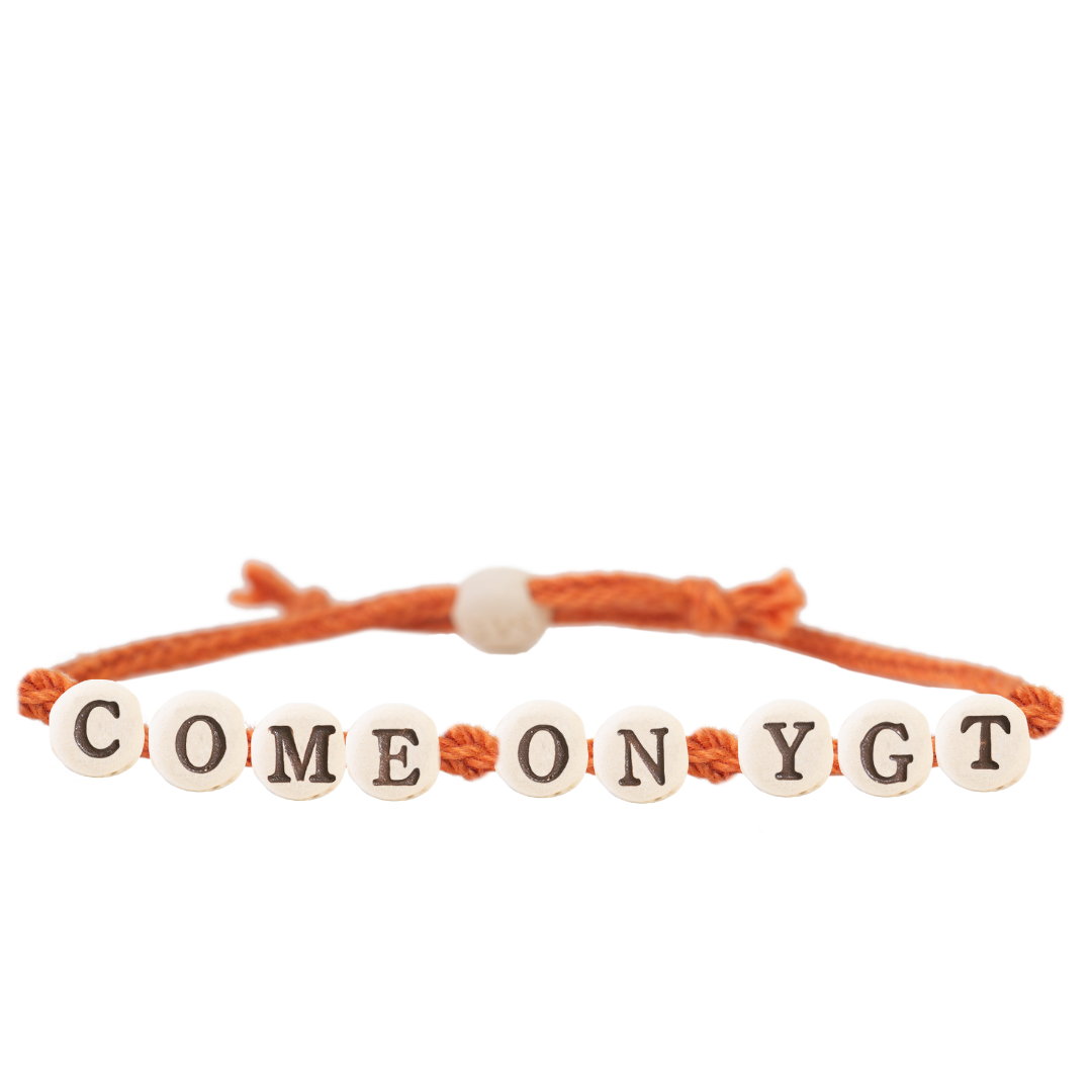 The Joni x MudLOVE Friendship Bracelet 4-Piece Set with an orange cord bracelet featuring beads that say &